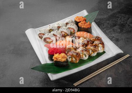 Set aus verschiedenen bunten Maki Sushi-Rollen, Nigiri und Gunkan mit Tiger Shrimps, tomago, Lachs, Thunfisch, chuka-Salat, Fliegender Fischkaviar, Thunfisch und Grün Stockfoto