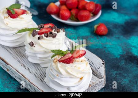 Pavlova-Baiser mit Schlagsahne und frischen Erdbeeren, Minzblättern. Selektiver Fokus. Kopierbereich. Stockfoto