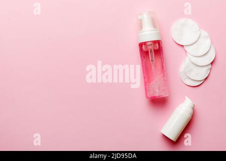 Micellar Reinigungswasser und Scheiben zur Entfernung von Kosmetika und zur Reinigung der Haut auf farbigem Hintergrund. Obere Ansicht des Kopierbereichs. Stockfoto