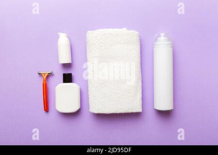 Rasierer-Set. Schermaschine, Handtuch, Lotion und Rasierschaum auf farbigem Hintergrund. Herren Bad Accessoires Draufsicht. Stockfoto