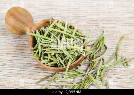 Der getrocknete Rosmarin würzt im Holzlöffel. Makro mit geringer Schärfentiefe. Stockfoto