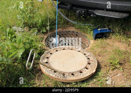 Steuerung eines Abwasserschachts mit Kamera und Fallschutz am Schacht Stockfoto