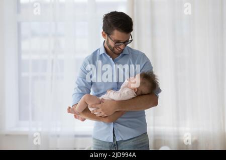 Junger fürsorglicher Dardist, der sein Baby auf den Armen hält Stockfoto