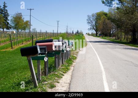 TRAVERSE CITY, MICHIGAN, USA - 16. Mai 2018: Mehrere amerikanische Briefkästen entlang der Straße im ländlichen Gebiet im Norden von Michigan Stockfoto