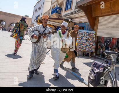 Zwei Straßenkünstler Musiker mit marokkanischen Musikinstrumenten laufen und spielen in Medina, Essaouira, Marokko Stockfoto