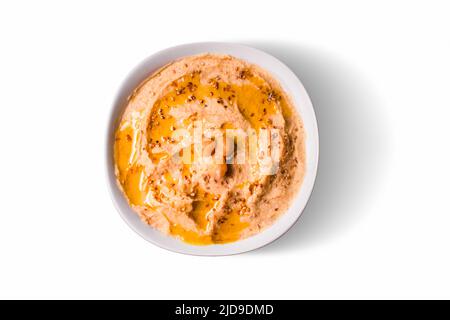 Draufsicht auf isolierte Kichererbsen Hummus mit Olivenöl und Sesam auf weißem Hintergrund zum Ausschneiden. Stockfoto