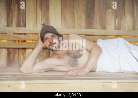 Mann, der in der Sauna relaxt Stockfoto