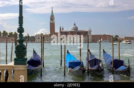 Venedig, Gondeln oder Gondeln und Wahrzeichen der Kirche San Giorgio Maggiore im Hintergrund. Italien, Europa. Stockfoto