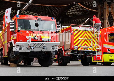 Hannover, Deutschland. 19.. Juni 2022. Ein Mann klettert auf einen Feuerwehrwagen auf dem Messegelände. Die Interschutz ist die Weltleitmesse für Feuerwehr, Rettung, Katastrophenschutz und Sicherheit und findet vom 20. Bis 25. Juni in Hannover statt. Kredit: Michael Matthey/dpa/Alamy Live Nachrichten Stockfoto