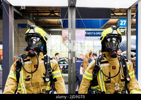 Hannover, Deutschland. 19.. Juni 2022. An einer Kabine werden zwei Schutzanzüge der Feuerwehr präsentiert. Die Interschutz ist die Weltleitmesse für Feuerwehr, Rettung, Katastrophenschutz und Sicherheit und findet vom 20. Bis 25. Juni in Hannover statt. Kredit: Michael Matthey/dpa/Alamy Live Nachrichten Stockfoto