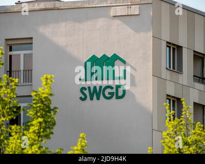 SWGD-Logo und ein Außengebäude in der Stadt. Die Sächsische Wohnungsgenossenschaft Dresden unterzeichnet. Stockfoto