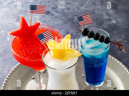 Drei Cocktails vom 4.. Juli, garniert mit USA-Flaggen und frischem Obst. Stockfoto