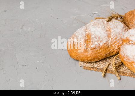 Hausgemachtes natürliches Brot. Verschiedene Arten von frischem Brot als Hintergrund, perspektivische Ansicht mit Kopierraum. Stockfoto