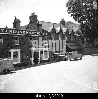 1957, historisch, Sommerzeit und Außenansicht des Tanronen Hotels, im Dorf Beddgelert, Gwynedd, Wales, Großbritannien. Das Hotel liegt im wunderschönen Snowdonia Nationalpark, Autos der Ära sind vor dem Gasthaus und in der Ferne, die Hügel von Snowdonia geparkt. Stockfoto