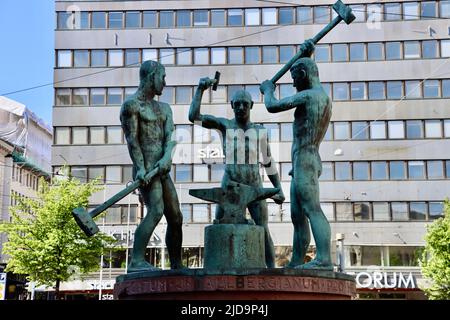 Drei Schmiede Skulptur (Kolme seppää) von Felix Nylund vor dem Stockmann Kaufhaus in Helsinki, Finnland Juni 2022 Stockfoto