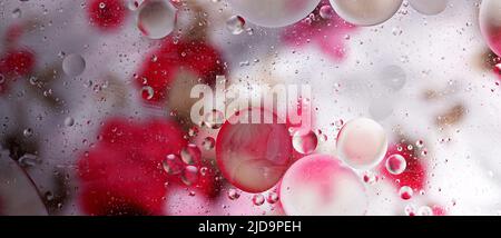 Draufsicht auf Ölblasen, die sich über verschiedene Schichten auf der Wasseroberfläche bewegen. Öltropfen auf einem abstrakten Hintergrund der Wasseroberfläche Stockfoto