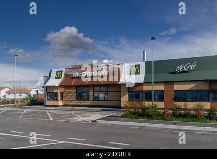 Savigliano, Italien - 16. Juni 2022: McDonald's-Restaurant mit Mc Drive am wolkenblauen Himmel. Die McDonald's Corporation ist die weltweit größte Kette von hamb Stockfoto