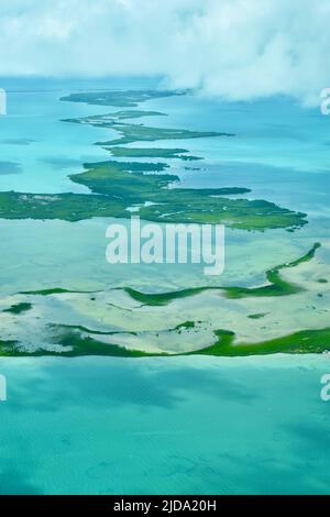 Luftaufnahme eines Atolls umgeben von klarem, türkisfarbenem Wasser in Belize, Mittelamerika. Stockfoto