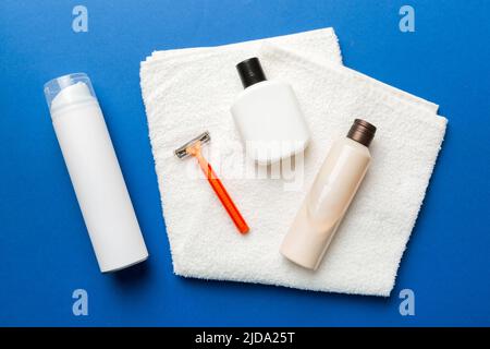 Rasierer-Set. Schermaschine, Handtuch, Lotion und Rasierschaum auf farbigem Hintergrund. Herren Bad Accessoires Draufsicht. Stockfoto