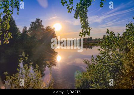 Abend am Fluss - Sonnenuntergang über ruhigem Wasser, Urlaub in der Natur Stockfoto