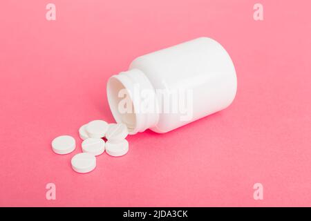 Verschiedene Medikamente und Nahrungsergänzungsmittel Pillen gegossen aus einer Medikamentenflasche Gesundheitsversorgung und medizinische Draufsicht auf farbigen Hintergrund. Stockfoto