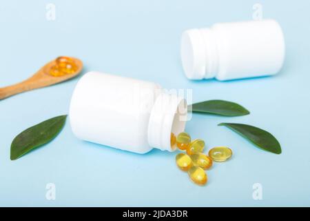 Omega-3 Kapseln liegen in einer weißen Flasche auf einem Tischhintergrund. Fischöl Tabletten Draufsicht. Biologisch aktive Zusatzstoffe. omega 6, Omega 9, Vitamin A, E, Stockfoto