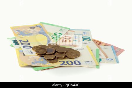 Euro-Banknoten, Geldscheine mit Wechselgeld, Geldscheine und Münzen auf hellem Hintergrund isoliert. Nahaufnahme. Stockfoto