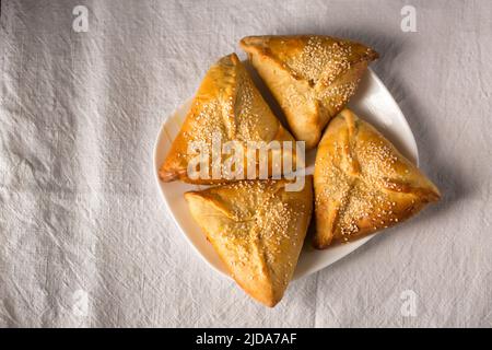 Rohige Kuchen mit Suluguni-Käse, bestreut mit Sesamsamen Stockfoto