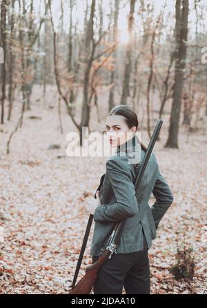 Jägerin auf der Jagd. Jagd im Herbstwald. Porträt der Schönheit Frau Hunter. Jagdsaison. Stockfoto