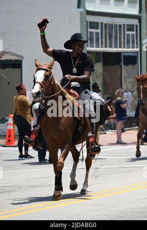 Afroamerikanische Cowboys marschieren zu Pferd durch Zebulon, NC, im Rahmen einer wochenlangen Feier der Befreiung von der Sklaverei. Stockfoto