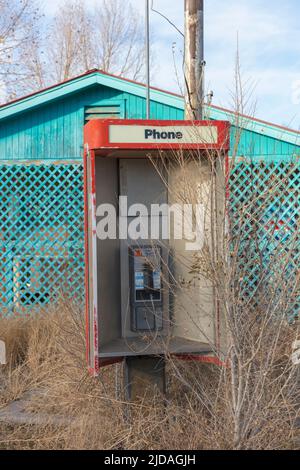 Verlassene alte Telefonzelle und leerer Laden am Straßenrand. Stockfoto