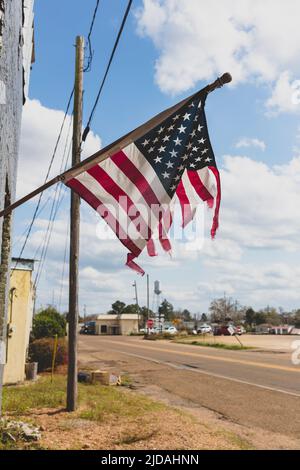 Zerfetzte amerikanische Flagge, die auf einem Gebäude an der Main Street fliegt. Stockfoto