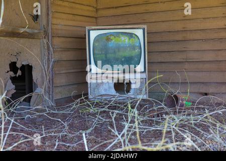 Alter Fernseher auf der Veranda eines verlassenen Gehöfts. Stockfoto