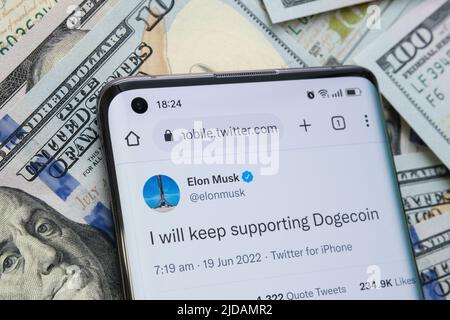 Der offizielle Tweet von Elon Musk über die Dogecoin-Unterstützung auf dem Smartphone wurde auf Dollarscheine gesetzt. Ich werde Dogecoin weiterhin unterstützen Stockfoto