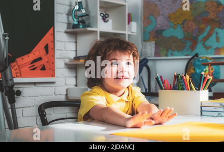 Kind in der Nähe einer Tafel im Klassenzimmer. Bildungsprozess. Kinder machen sich bereit für die Schule. Stockfoto