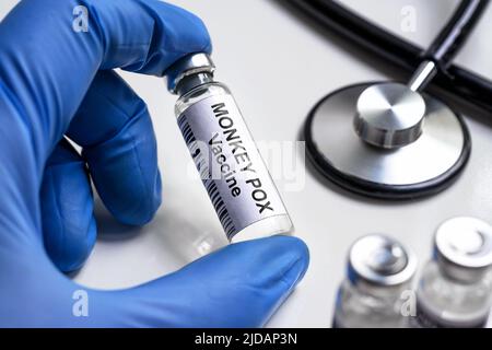 Affenpocken-Impfstoff in der Hand des Arztes, Flasche für Schuss von Pocken, Schutz vor Monkeypox-Virus auf dem Labortisch. Konzept von Monkeypox, medizinische Injecti Stockfoto