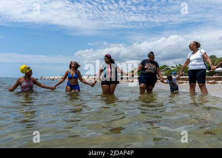 Dania Beach, Florida, USA. 18.. Juni 2022. Die Künstlerin Nerissa Street of Fort Laudedale (2. v.l.), Organisatorin von ''Junteenth for Joy'', feiert den Zugang zum Wasser im Dr. von D. Mizell-EULA Johnson State Park in Dania Beach. Der Park war der einzige afroamerikanische abgetrennte Strand in Fort Lauderdale in den 1950er Jahren und war über Land nicht erreichbar. (Bild: © Orit Ben-Ezzer/ZUMA Press Wire) Stockfoto