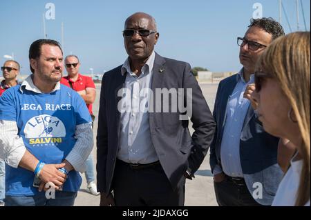 Catanzaro, Catanzaro, Italien. 19.. Juni 2022. TONY IWOBI (C) mit Parteimitgliedern in Roccella Jonica gesehen. Senator TONY CHIKE IWOBI, der für die Lega Nord gewählt wurde, besuchte den erste-Hilfe-Platz der Migranten im Hafen von Roccella Jonica in der Region Kalabrien. DER IN Marokko geborene italienische Politiker SOUAD SBAI begleitete IWOBI mit regionalen Vertretern der Liga, einer richtigen politischen Partei, um die kritischen Bedingungen des erste-Hilfe-Orts und die Arbeitsbedingungen der lokalen Sicherheitskräfte zu beurteilen. (Bild: © Valeria Ferraro/ZUMA Press Wire) Stockfoto