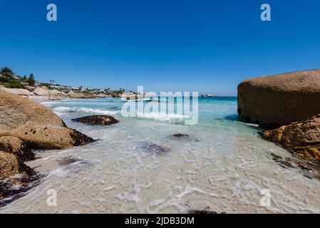 Große Felsen umrahmen den Blick auf Strandhäuser entlang der felsigen Küste am Clifton Beach am Atlantik; Kapstadt, Westkap, Südafrika Stockfoto