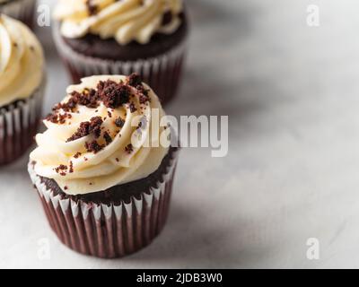 Brownie-Muffins aus Schokolade mit Rahm und geriebener Schokolade. Isoliert auf weißem Hintergrund. Auf dem Foto befinden sich keine Personen. Es gibt freien Speicherplatz zum Eingeben Stockfoto