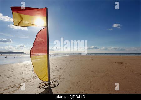 Rettungsschwimmflagge am Strand, die den sicheren Bereich zum Schwimmen am Woolacombe Beach in North Devon markiert; Südwestengland, Großbritannien, Großbritannien Stockfoto