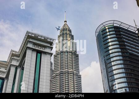 Kuala Lumpur, Malaysia - 16. Juni 2022: Ein Turm der Zwillingstürme KLCC zwischen dem Bank Simpan National oder BSN Tower. Petronas Twin Towers, der f Stockfoto