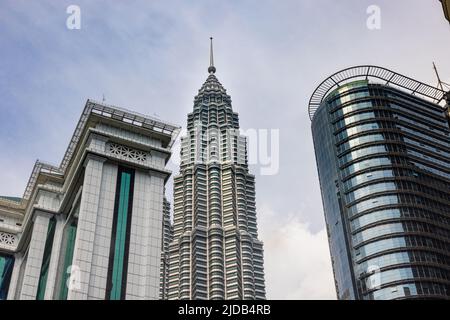 Kuala Lumpur, Malaysia - 16. Juni 2022: Ein Turm der Zwillingstürme KLCC zwischen dem Bank Simpan National oder BSN Tower. Petronas Twin Towers, der f Stockfoto