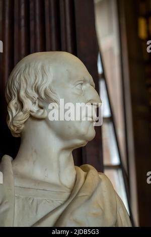 Dublin, Irland - 2. Juni 2022: Der Long Room der alten Bibliothek am Trinity College. Marmorbüsten von großen Menschen und Regale mit antiken zu Stockfoto