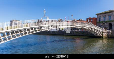 Dublin, Irland - 1. Juni 2022: Ha'Penny Bridge und offiziell die Liffey Bridge, eine Fußgängerbrücke, die im Mai 1816 über den Fluss Liffey in Dublin gebaut wurde Stockfoto