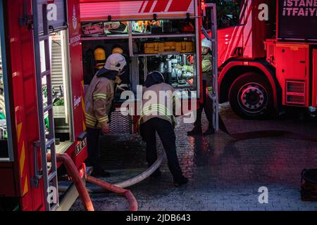 Istanbul, Türkei. 19.. Juni 2022. Feuerwehrmänner werden während der Brandlöschung durch die Löschfahrzeuge gesehen. Das Feuer, das in dem 2-stöckigen Holzgebäude in den Wäldern in der Beylerbeyi Sair Asaf Halet-Croebi-Straße in Uskudar, Istanbul, ausbrach, wurde nach etwa 1 Stunden Eingreifen der Feuerwehrleute unter Kontrolle gebracht. Kredit: SOPA Images Limited/Alamy Live Nachrichten Stockfoto