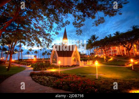 Die Kapelle am Meer im Grand Wailea Resort in Wailea, Maui, Hawaii, USA, erleuchtet bei Sonnenuntergang durch leuchtende Lichter Stockfoto