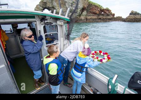 Freunde und Familie einer verstorbenen Person erinnern sich an ihre Lieblingsfischerei in der Kachemak Bay während einer Gedenkstätte auf dem Wasser in der Nähe von Homer, Alaska Stockfoto