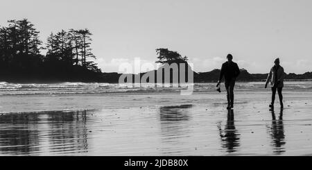 Zwei Personen zu Fuß am Chesterman Beach, Vancouver Island; British Columbia, Kanada Stockfoto