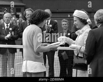 Aktenfoto vom 01-07-1977 von der britischen Virginia Wade erhält die Siegerpokale „Challenge Trophy“ von der Queen on Center Court. Die Königin hat nur sporadische Besuche in Wimbledon gemacht, aber 1977 markierte sie ihr Silver Jubilee, indem sie die Trophäe einem britischen Champion übergab, nachdem Virginia Wade Betty Stove besiegt hatte, um den Einzel-Titel der Frauen zu gewinnen. Ausgabedatum: Montag, 20. Juni 2022. Stockfoto